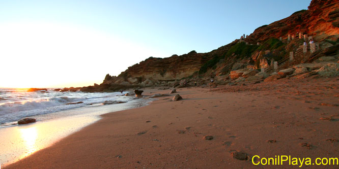 Vista de la cala al atardecer. A la derecha la escaleras de bajada.