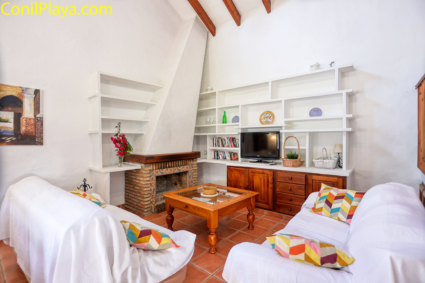 salón con sofá, chimenea y mesa comedor.