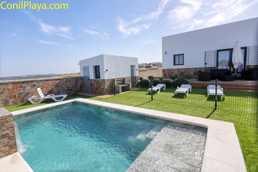 Zona de piscina privada junto a la casa en Vejer con césped y tumbonas