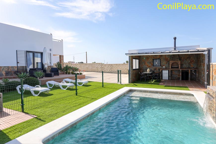 Piscina con zona de césped y barbacoa en Vejer
