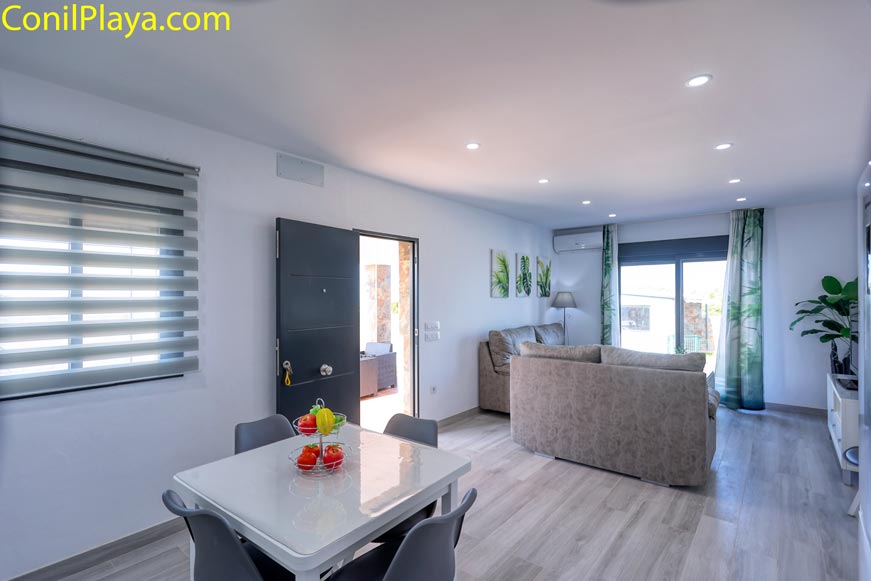 Primer plano de la mesa comedor de la cocina y al fondo el salón con sofá