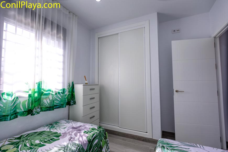 Dormitorio con armario empotrado y muebles modernos visto desde la puerta