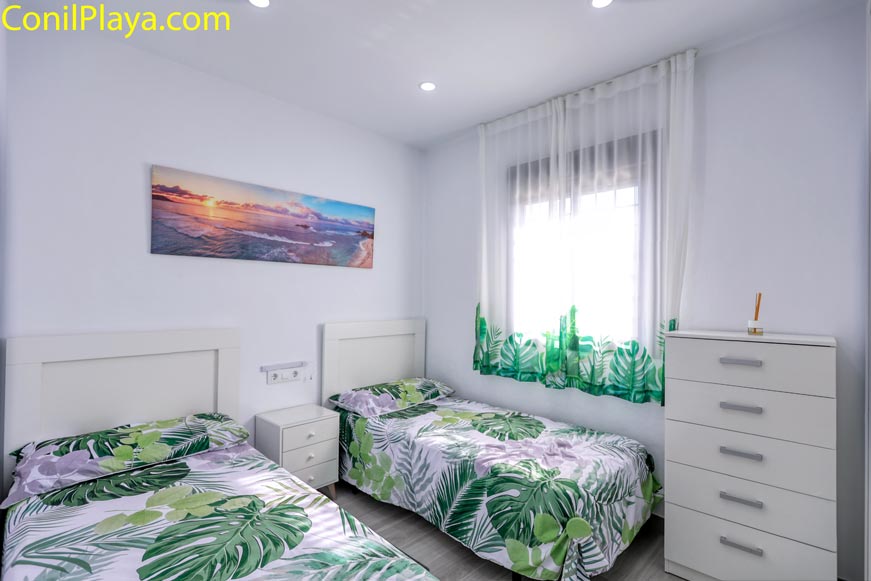 Dormitorio con dos camas individuales y decoración tropical