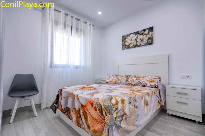 Dormitorio principal con cama de matrimonio y decoración floral moderna