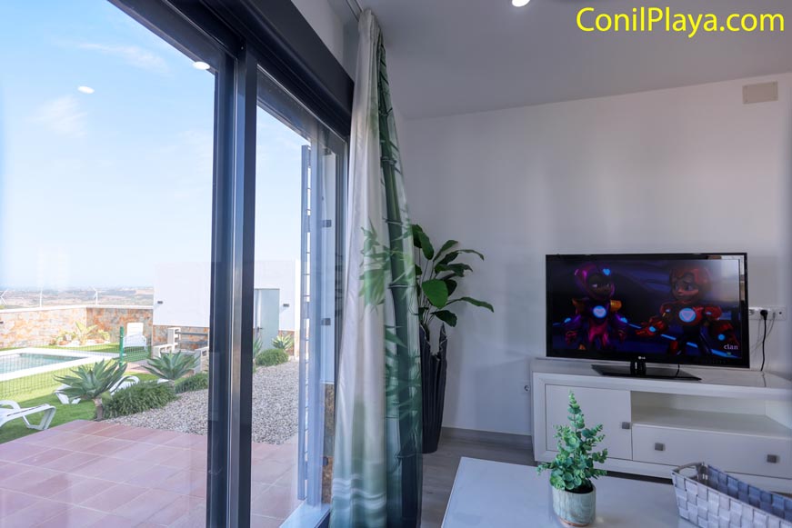 Vista desde el salón con televisor y acceso directo al exterior