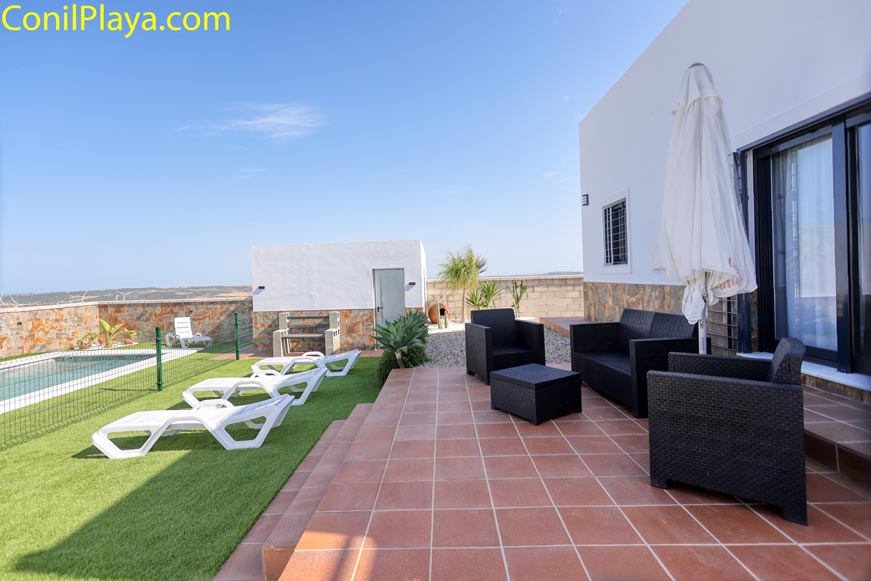 Zona chill out junto a piscina con tumbonas y mobiliario exterior moderno