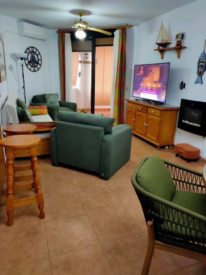 Salón con sillones verdes tele mesa madera y detalles marineros