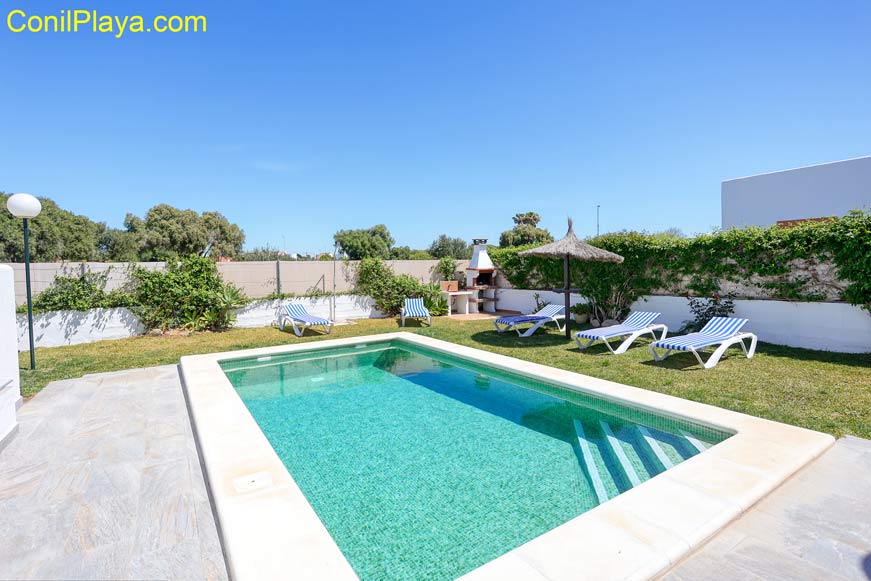 Jardín del chalet con la piscina. A la izquierda podemos ver la antena parabólica.